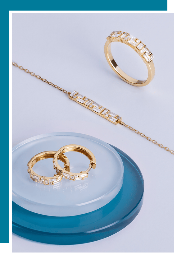 Gold jewelry pieces arranged on a blue and white display surface